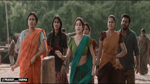 a group of people are walking on a beach and the words pranay varma are on the bottom of the screen
