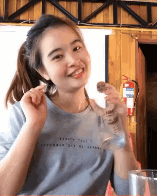a woman wearing a blue shirt that says ' a33tm ' on it