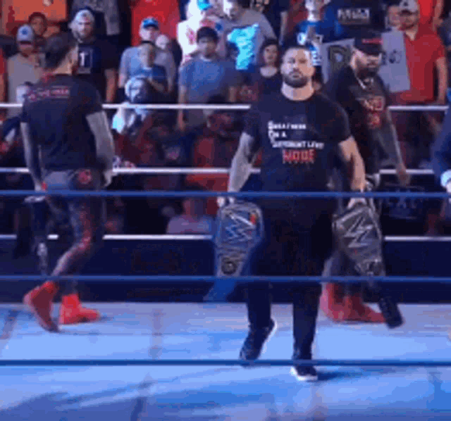 a man in a wrestling ring with a t-shirt that says ' roman reigns ' on it