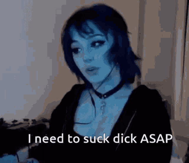 a woman with blue hair is wearing a choker and a black jacket and says i need to suck dick asap .