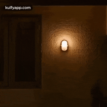 there is a light on the wall next to a window .