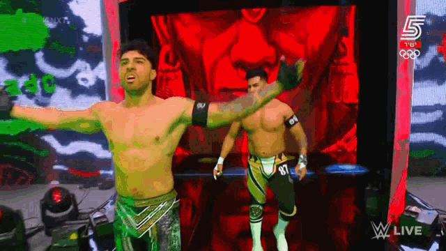 two wrestlers are standing in front of a screen that says wwe live