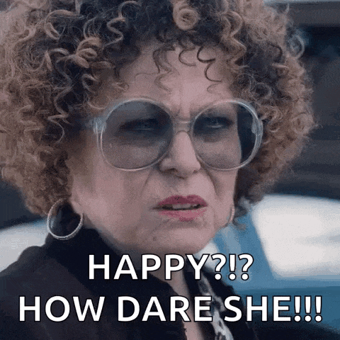 a woman with curly hair and glasses is making a funny face and says `` happy ? how dare she !! ''