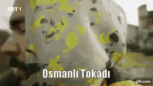 a close up of a person 's face with the words " osmanli tokadir " written on the bottom