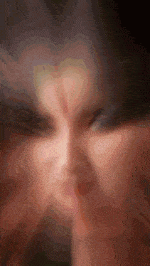 a blurry picture of a person 's face with a slight smirk on their face