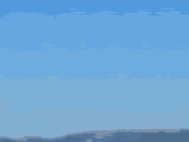 a cat is flying through the air with a blue sky in the background
