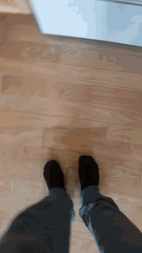 a person wearing black socks standing on a wood floor