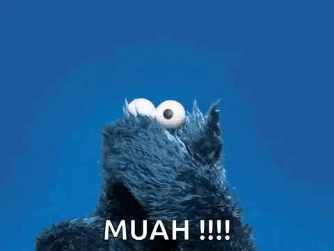 cookie monster from sesame street says muah !!! in front of a blue background