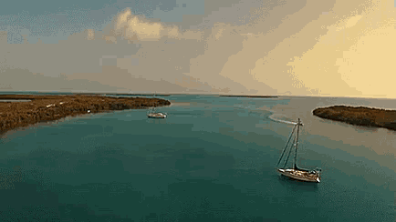 an aerial view of a sailboat in the ocean