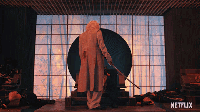 a man holding a sword stands in front of a netflix sign