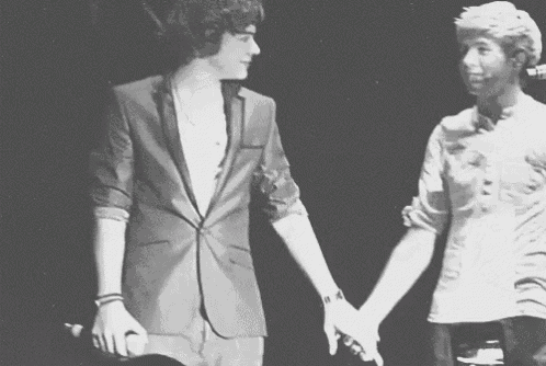 a man in a suit and a man in a white shirt are holding hands