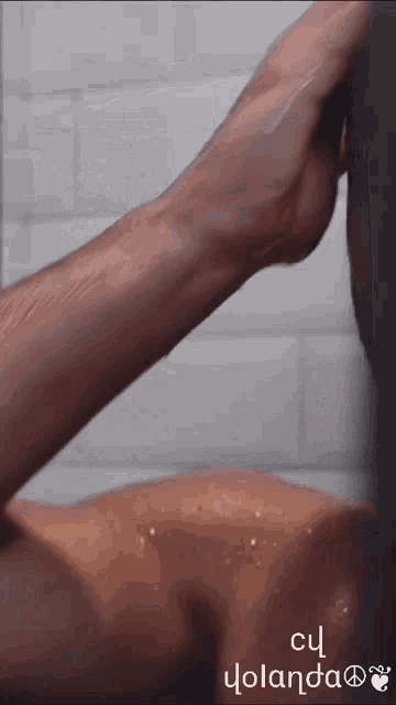 a man taking a shower with the words cu yolanda on the bottom right