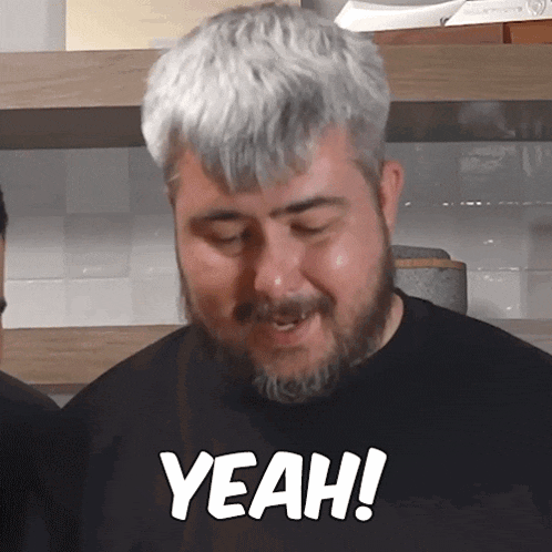 a man with a beard is wearing a black shirt that says " yeah "