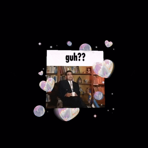 a man in a suit and tie is sitting in front of a bookshelf holding a cup of coffee and asking the question guh ?