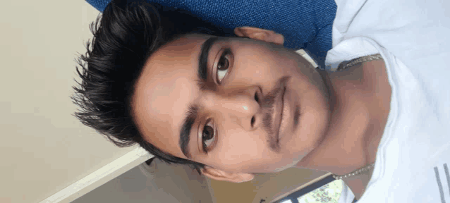 a close up of a young man 's face with a blue background