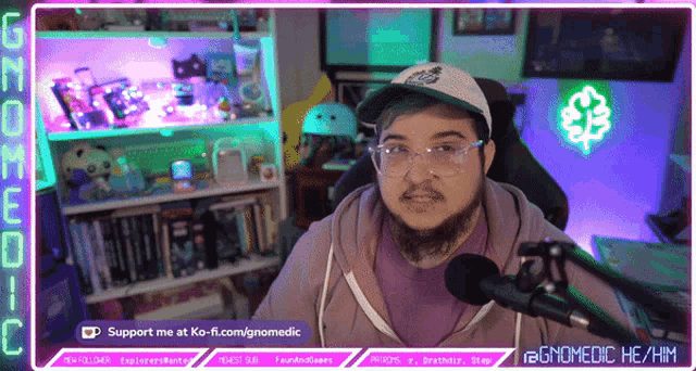 a man sitting in front of a microphone with the words support me at ko-fi.com/gnomedic on the bottom right