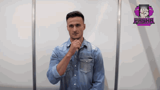 a man in a denim shirt stands in front of a sign that says pasha on it