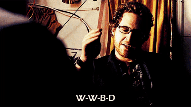 a man wearing a denim vest with w-w-b-d written on the front