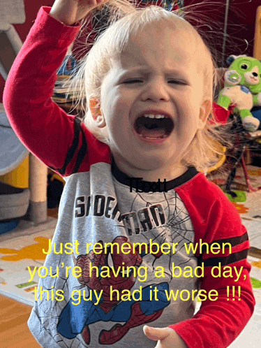 a young boy wearing a spider man shirt is crying