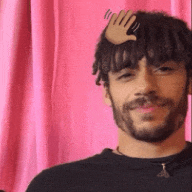 a man with a beard has a hand on his head