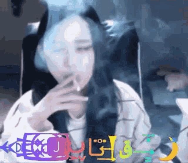 a woman is smoking a cigarette while sitting in a chair with her eyes closed .