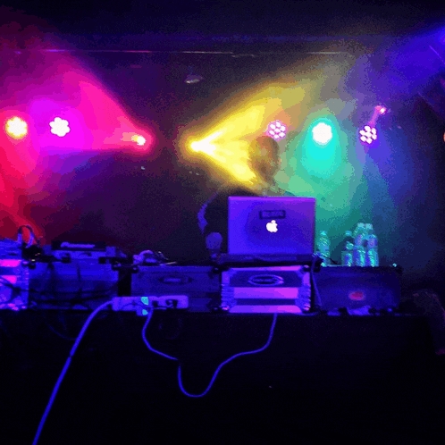 a laptop with an apple logo sits on a stage
