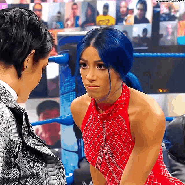 a woman with blue hair is looking at another woman