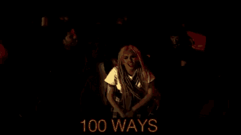 a woman with dreadlocks is dancing in a dark room with the words 100 ways in red
