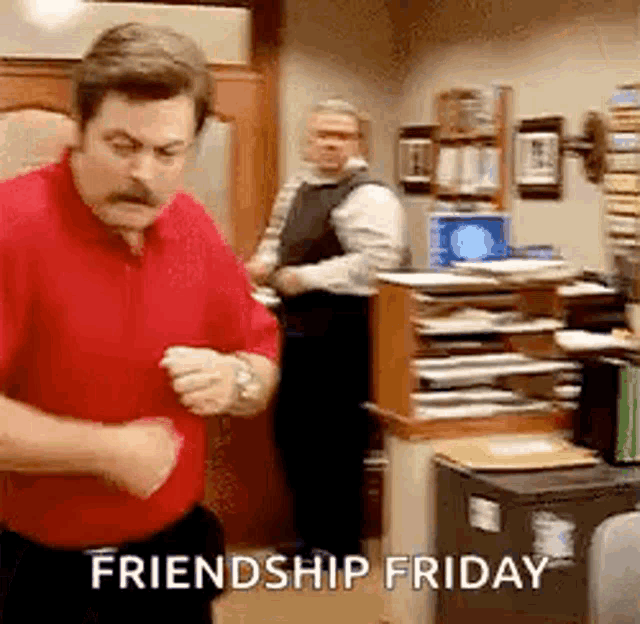 a man in a red shirt is dancing in an office with the words `` friendship friday '' written on the bottom .