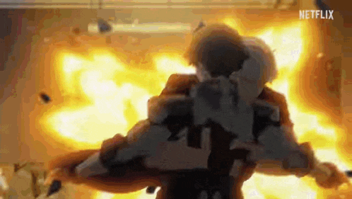 a man is holding a gun in front of a large explosion .