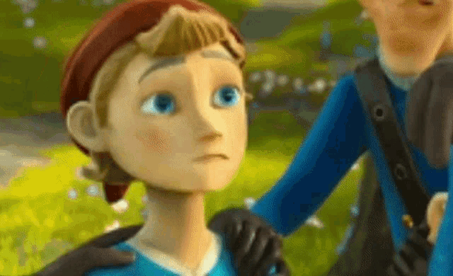 a cartoon character with blue eyes and a red hat is being held by a man in a blue shirt .