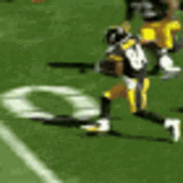 a blurred image of a football player running on a field .