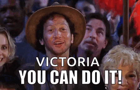 a man in a hat is sitting in a crowd of people and says `` victoria you can do it ! ''