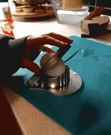 a person is cutting an egg with a knife on a blue cutting board