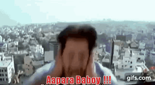 a man is covering his ears in front of a city skyline .