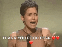 a woman is giving a speech in front of a microphone and saying thank you pooh bear .
