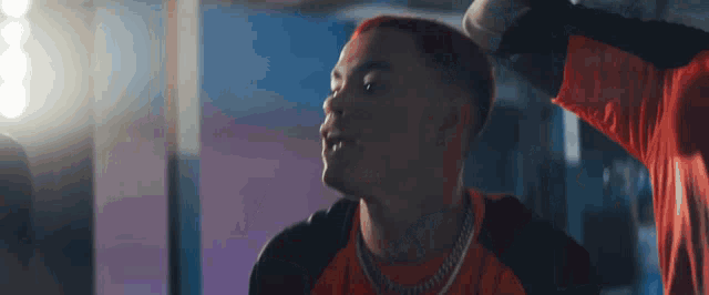 a man with red hair is wearing a red shirt and black jacket