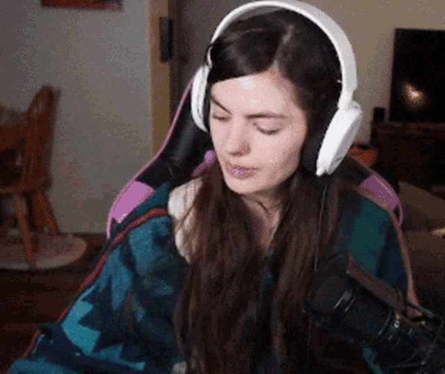 a woman wearing headphones is sitting in a chair with a microphone