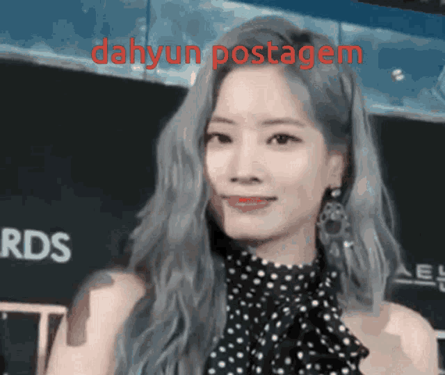 a woman in a black and white polka dot dress with the words dahyun postagem on the bottom