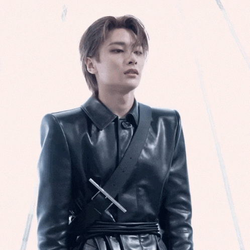 a young man wearing a black leather jacket with a belt around his waist