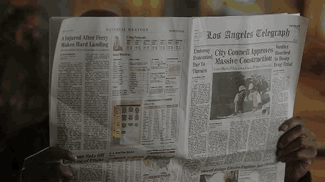 a person is reading the los angeles telegraph on a sunny day