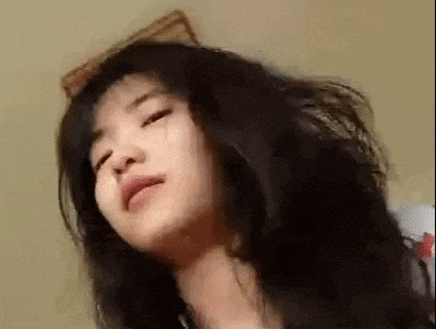 a close up of a woman with long hair making a funny face .