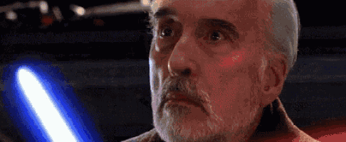 a close up of a man with a beard holding a lightsaber .