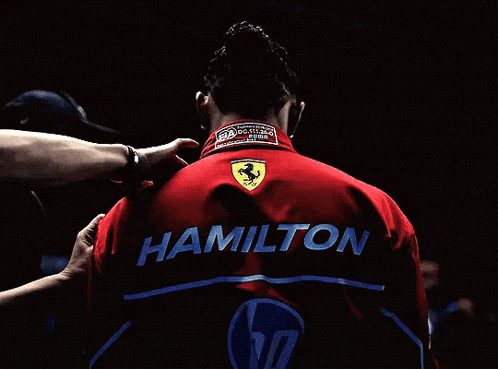 a person wearing a red jacket with the name hamilton on it