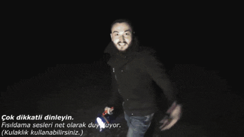 a person is walking in the dark with a flashlight in their hand