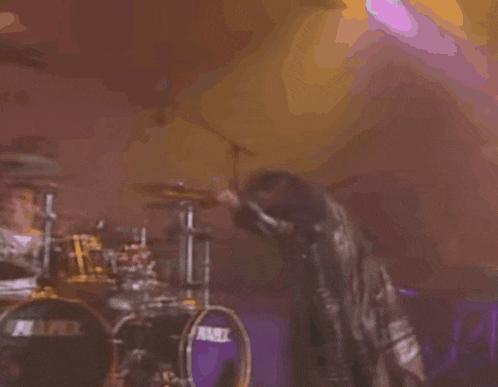 a person is standing on a stage in front of a drum set that says mapex on it .