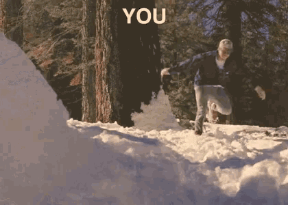 a man is jumping over a snowy hill with the word you behind him