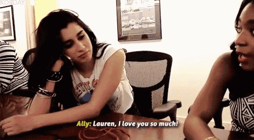 two women are sitting at a table and one of them is saying " ally : lauren i love you so much "