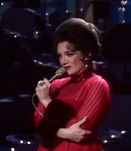 a woman in a red dress is holding a microphone