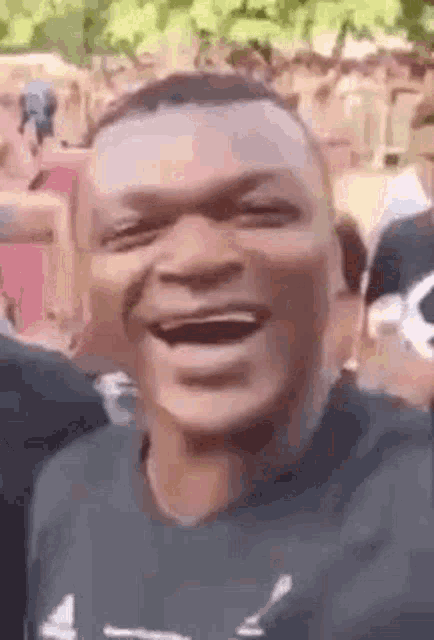 a man is laughing in a crowd of people .